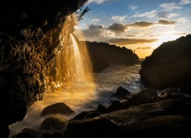 Waterfall near Queens Bath in Princeville Kauai clipart