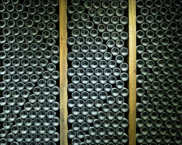 Fondos de miles de botellas de vino en la antigua bodega — Foto de Stock