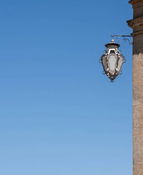 Detalhe da lâmpada ornamentada no lado do edifício com céu azul — Fotografia de Stock