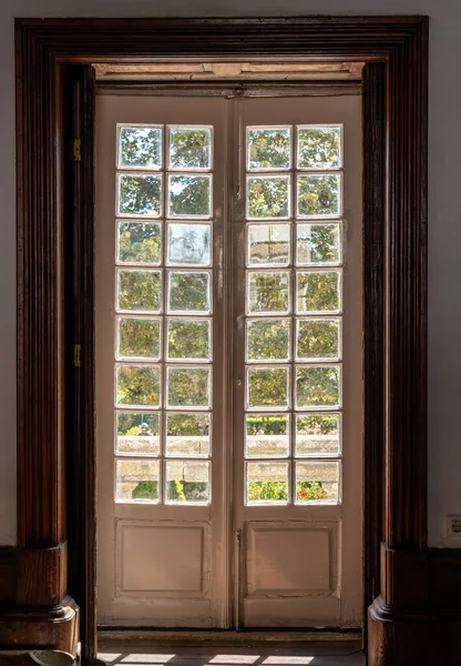 古旧的木制玻璃门通向旧楼华丽的花园 — 图库照片