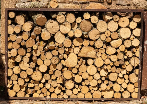 Stapel von Holzstämmen für Brennholz außerhalb der Steinmauer des Hauses — Stockfoto