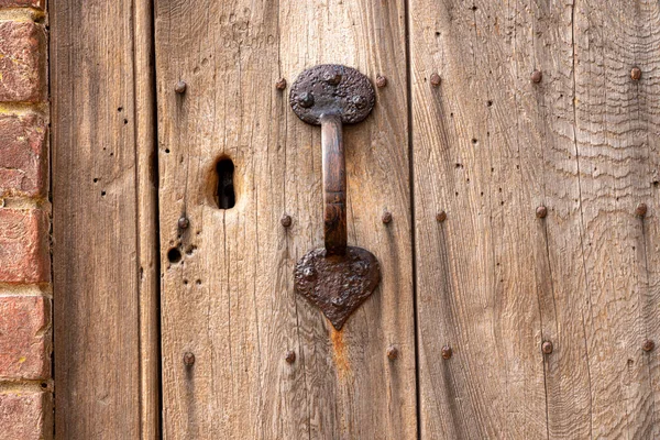 Rostfritt dörrhandtag på gammal väderbevuxen dörr med nyckelhål — Stockfoto