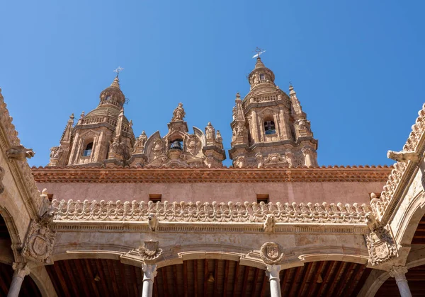 Casa de la Conchas and its carved balconies with Clericia church in Salamanca Spain — ストック写真