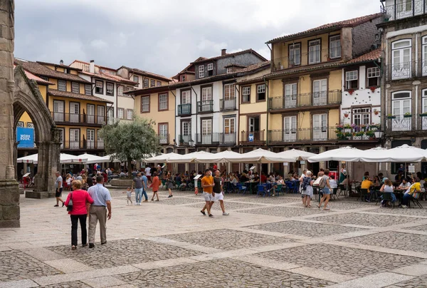 A turisták séta Largo da Oliviera a hagyományos házak Guimaraes Portugáliában — Stock Fotó