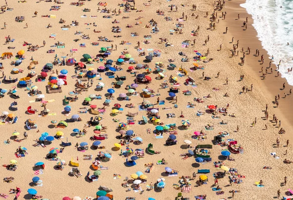 Повітряний вид туристів на пляжі Назаре в Португалії в переповнений літній день. — стокове фото