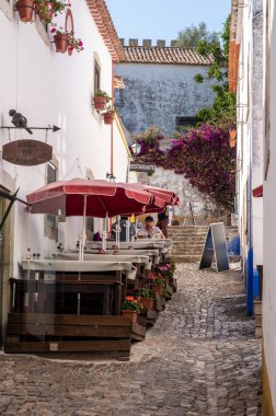 Portekiz 'in orta kesimindeki eski duvarlı Obidos kasabasında küçük bir bar veya kafe.