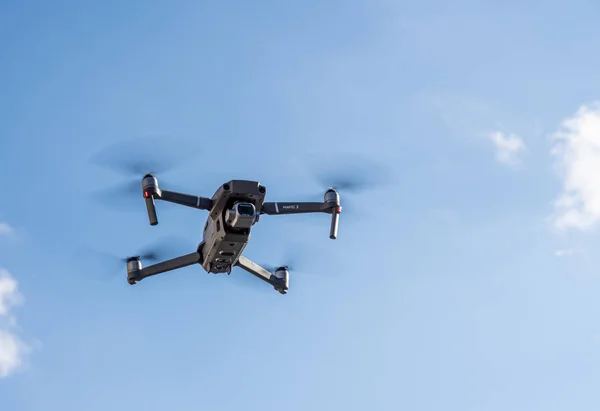 Dji Mavic Pro 2 drone vliegt boven de camera tegen de blauwe lucht — Stockfoto