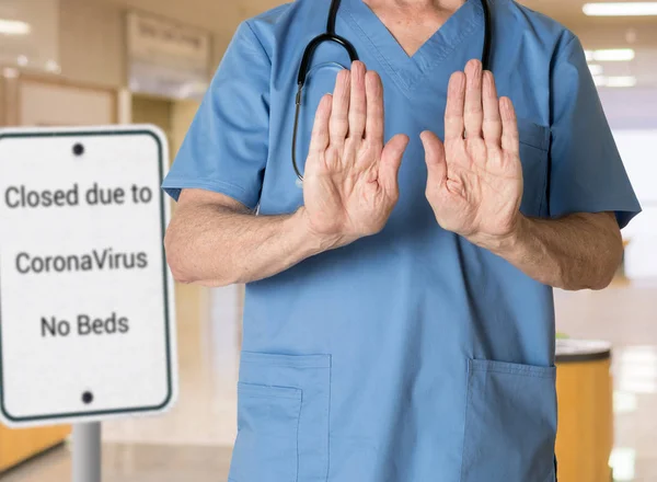 Senior doctor in scrubs refusing entry to hospital because of Corona Virus — ストック写真