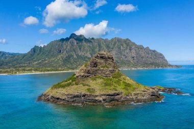 Aerial view of chinamans hat by Kualoa regional park with mountains in background clipart