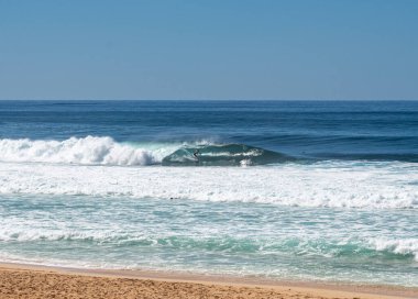 Oahu 'nun kuzey kıyısındaki Banzai Pipeline plajında bir tüpün içinde sörfçü.