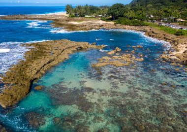 Sharks Cove Hawaii 'de şnorkelle yüzmek için kayaların havadan çekilmiş görüntüleri.