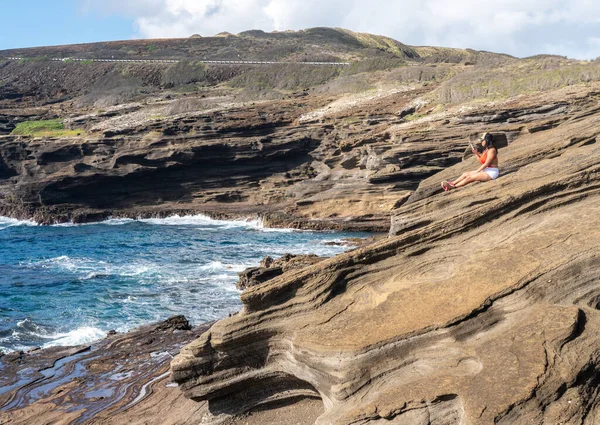 Woman taking a selfie on the eroded cliffs at Halona near Waikiki on Oahu — Stock Photo, Image