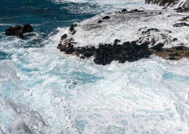 Winter waves crash on the rocky shoreline at Kaena Point on Oahu