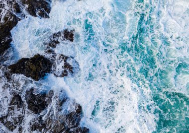 Vertical top down view of waves crashing over rocks on Lumahai beach on Kauai