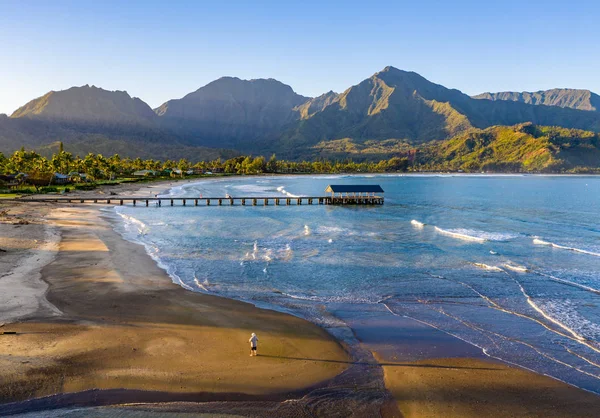 Tiro aéreo de dron de hombre en la arena de la playa Hanalei en la orilla norte de Kauai en Hawai —  Fotos de Stock