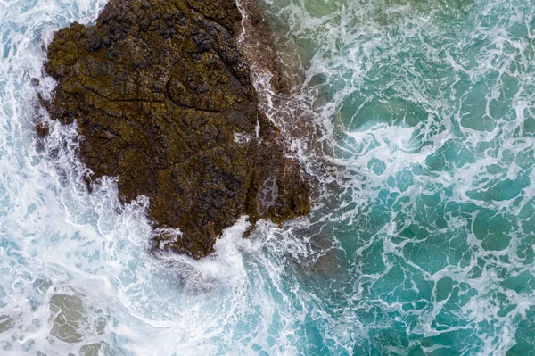 Вид сверху вниз на волны, ударяющиеся о скалы на пляже Лумахай на Кауаи — стоковое фото