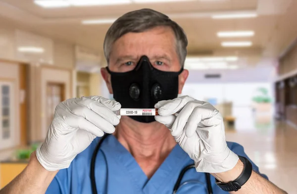 Médico varón mayor usando máscara y sosteniendo el resultado de la prueba de Coronavirus — Foto de Stock