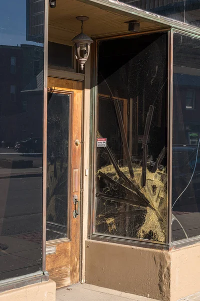 Sprucken och skadad fönsterruta från dörr till butik i centrum — Stockfoto