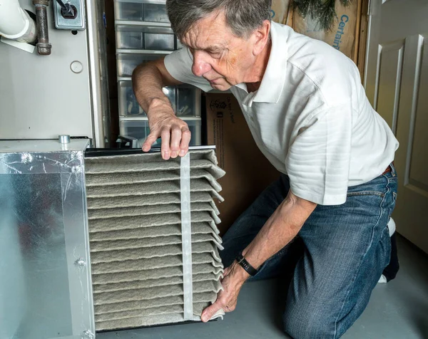 Homme âgé changeant un filtre à air sale dans un four CVC — Photo