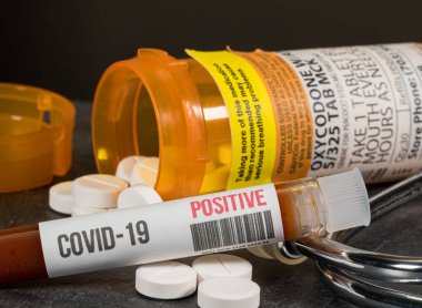 Pozitif koronavirüs kan testiyle birlikte genel oksikodon opioid tablet şişesi.
