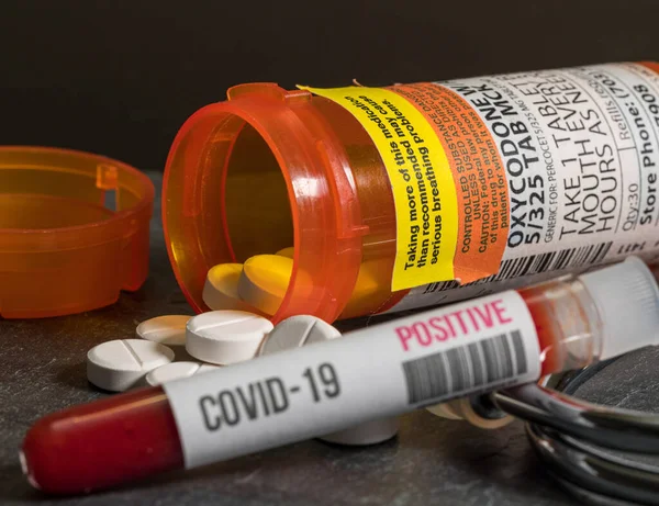 Pozitif koronavirüs kan testiyle birlikte genel oksikodon opioid tablet şişesi.
