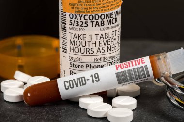 Pozitif koronavirüs kan testiyle birlikte genel oksikodon opioid tablet şişesi.
