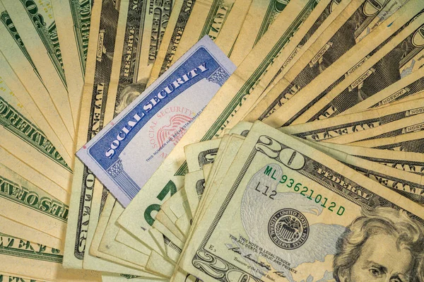 Social security card among thousands of US dollar bills — Stock Photo, Image