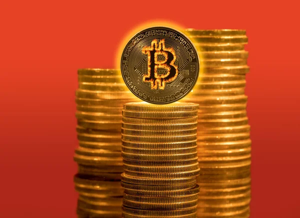 Bitcoin mit Flammeneffekt auf Stapel von Goldmünzen, um den Preisanstieg der Cyberwährung anzuzeigen — Stockfoto
