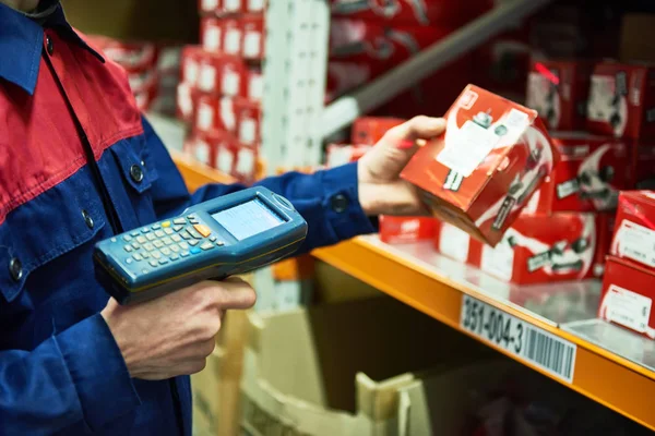 Magazijnmedewerker auto reserveonderdeel scannen met laser barcodescanner — Stockfoto