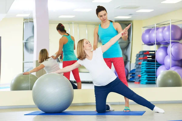 Gravid kvinna gör fitness boll träning med tränare — Stockfoto