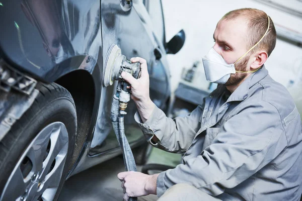 Reparador de automóviles moliendo la carrocería del coche del automóvil — Foto de Stock