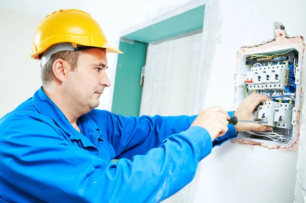 Electrician installing switching electric actuator in fuse box — Stock Photo, Image