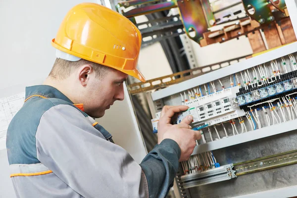 Électricien travaille avec testeur de compteur électrique dans la boîte à fusibles — Photo