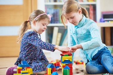 Çocuklar bloklarla içeride oynuyorlar