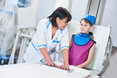 Nurse assistant with little boy preparing or x-ray radiography clipart