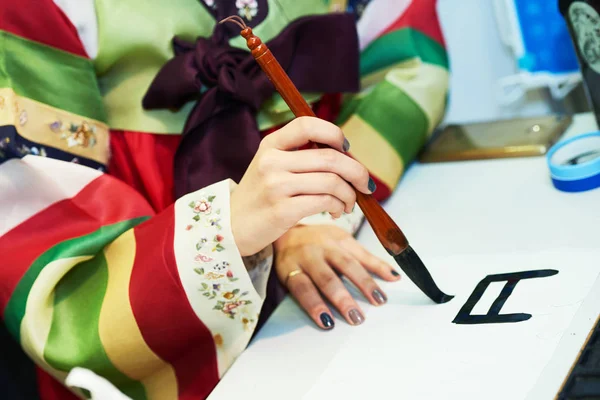 Caligrafia. Mão feminina escrevendo hieróglifo coreano — Fotografia de Stock