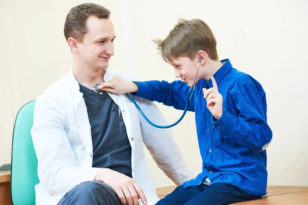 Child boy examining male doctor with stethoscope in hospital — Stock Photo, Image