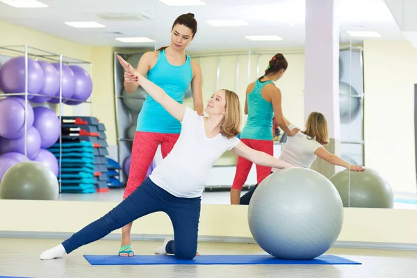 Pregnant woman doing fitness ball exercise with coach — Stock Photo, Image