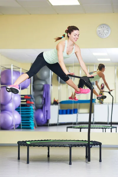 Fitness aktivitet. Kvinna hoppar på studsmatta — Stockfoto