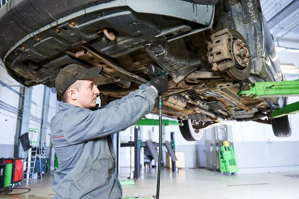 Auto repair service. Mechanic works with car suspension — Stock Photo, Image