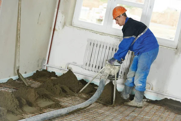 Trabalhador estucador na construção de pisos de cimento — Fotografia de Stock