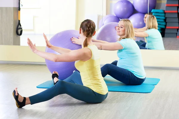 Pregnant woman doing fitness ball exercise with coach — Stock Photo, Image