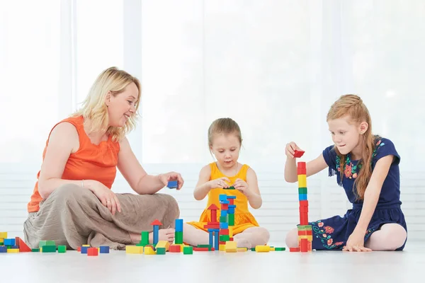 母亲和孩子们玩积木 — 图库照片