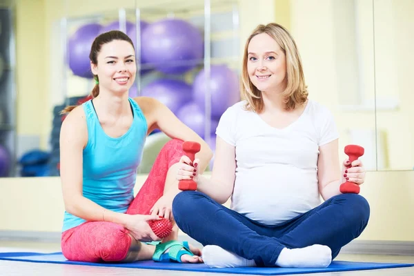 Pregnant woman doing fitness ball exercise with coach — Stock Photo, Image