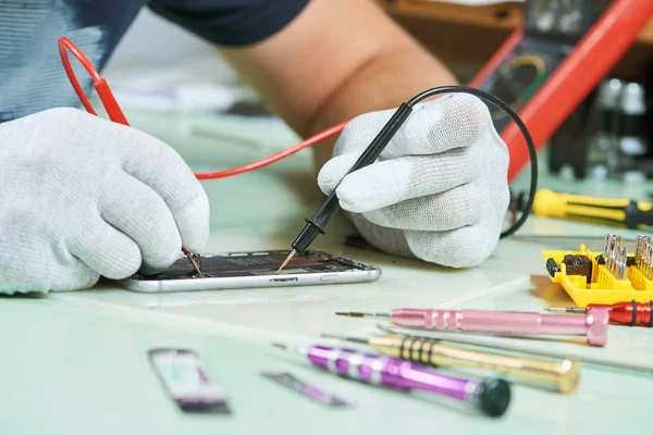 Smart phone repair. repairman testing electric circuit — Stock Photo, Image