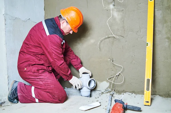 Plumber worker installing sewage pipes in sewerage system — Stock Photo, Image