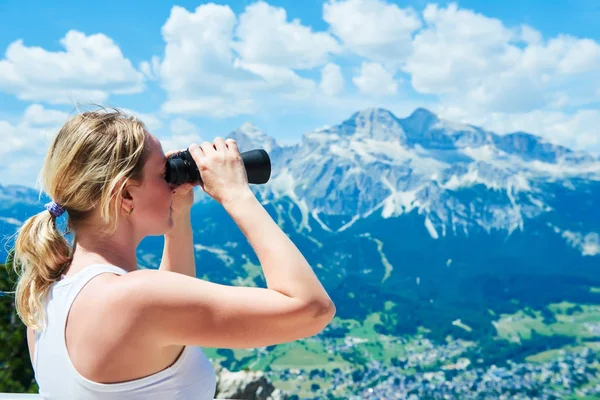 Mulher com binóculos assistindo montanhas — Fotografia de Stock