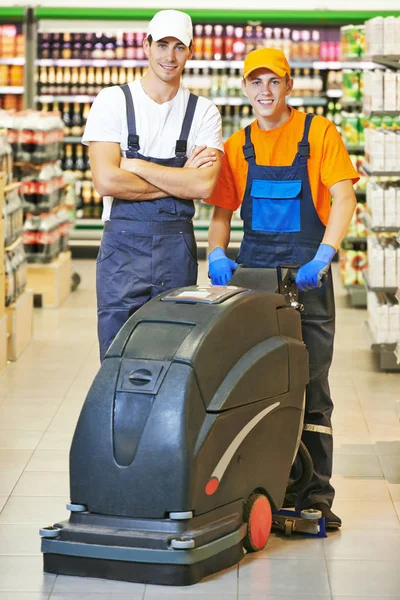 Manliga arbetstagare rengöring shop hall — Stockfoto