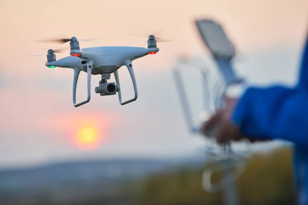 Drone repülő és üzemeltetője a távoli controlsunset — Stock Fotó