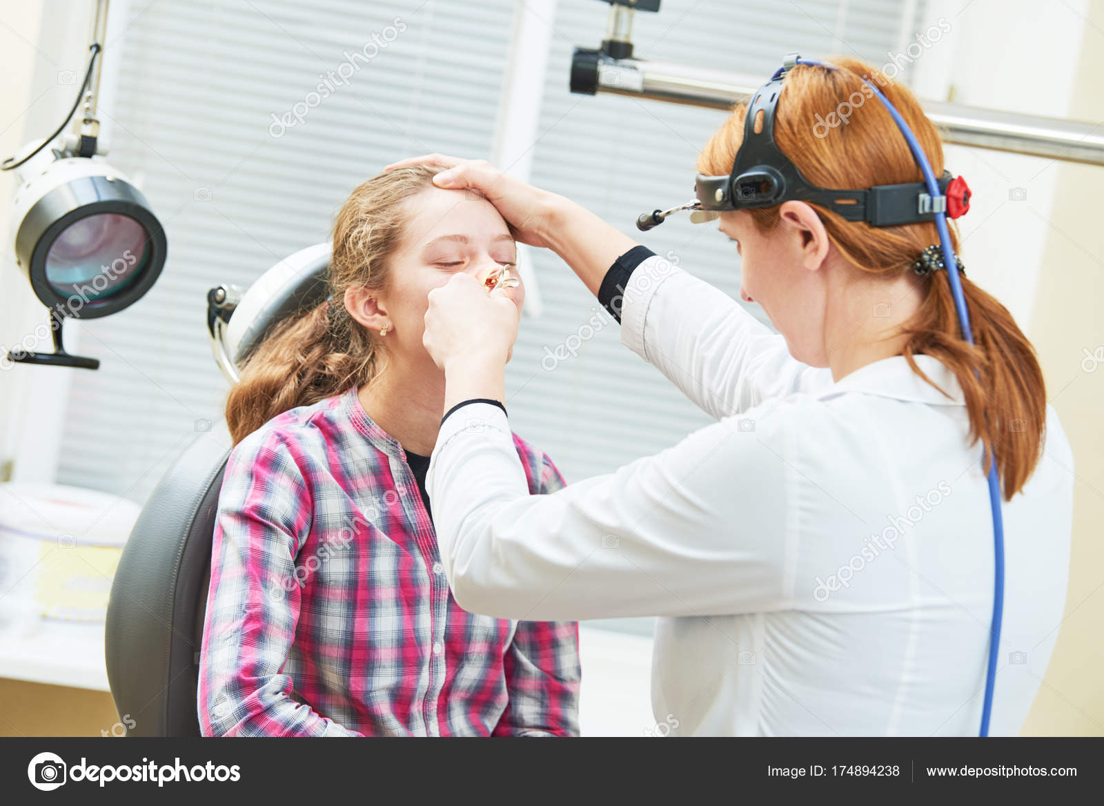 Female doctor of ENT ear nose throat at work examining girl nose Stock
